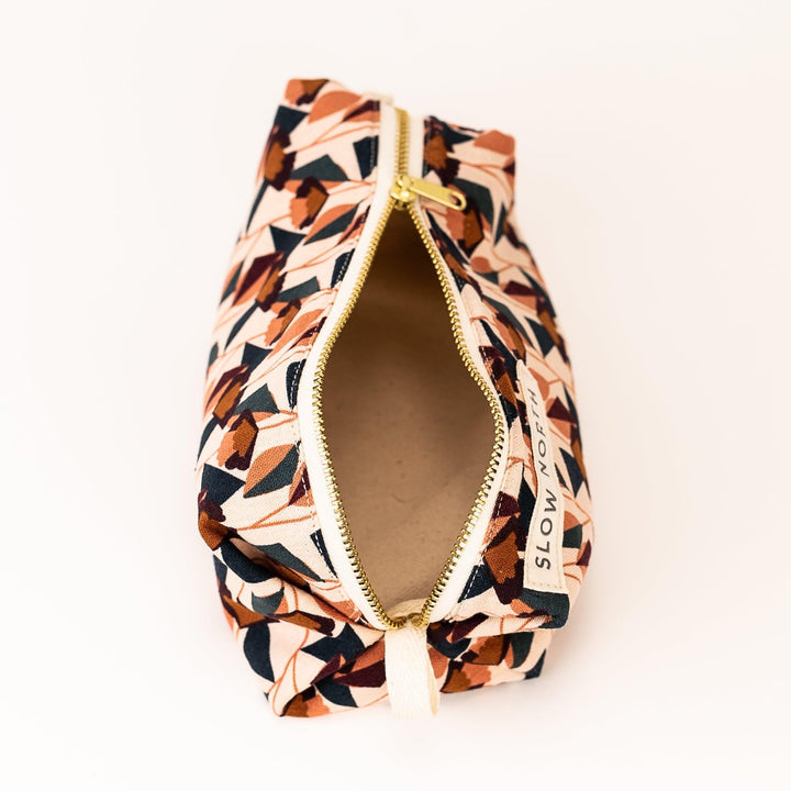 Blush cotton-linen pouch with floral motif and elegant compact design.