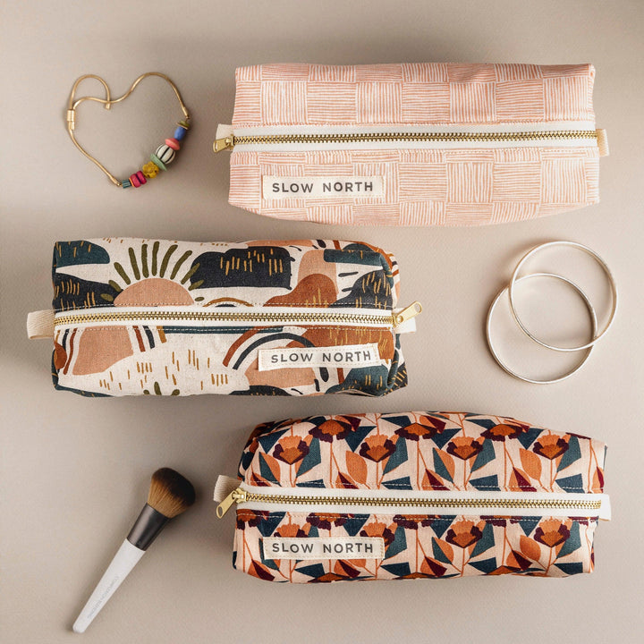 Compact blush pouch with floral artwork and self-standing form.