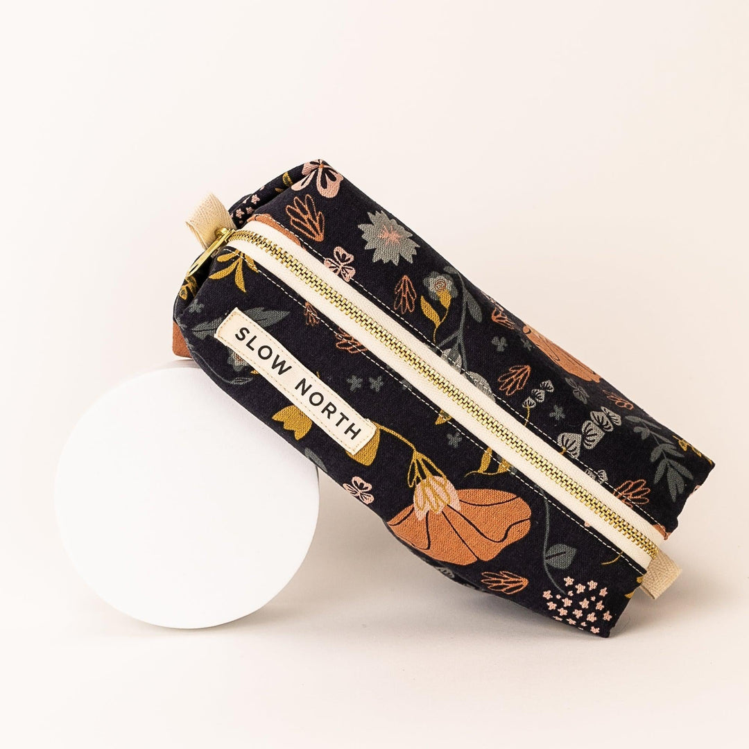 Neutral-colored cotton-linen travel pouch with compact structured form.