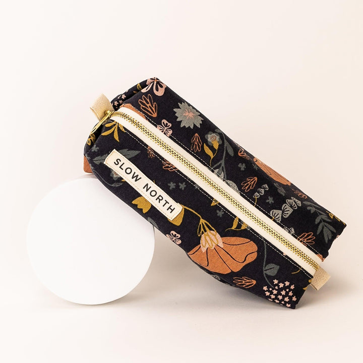 Neutral-colored cotton-linen travel pouch with compact structured form.