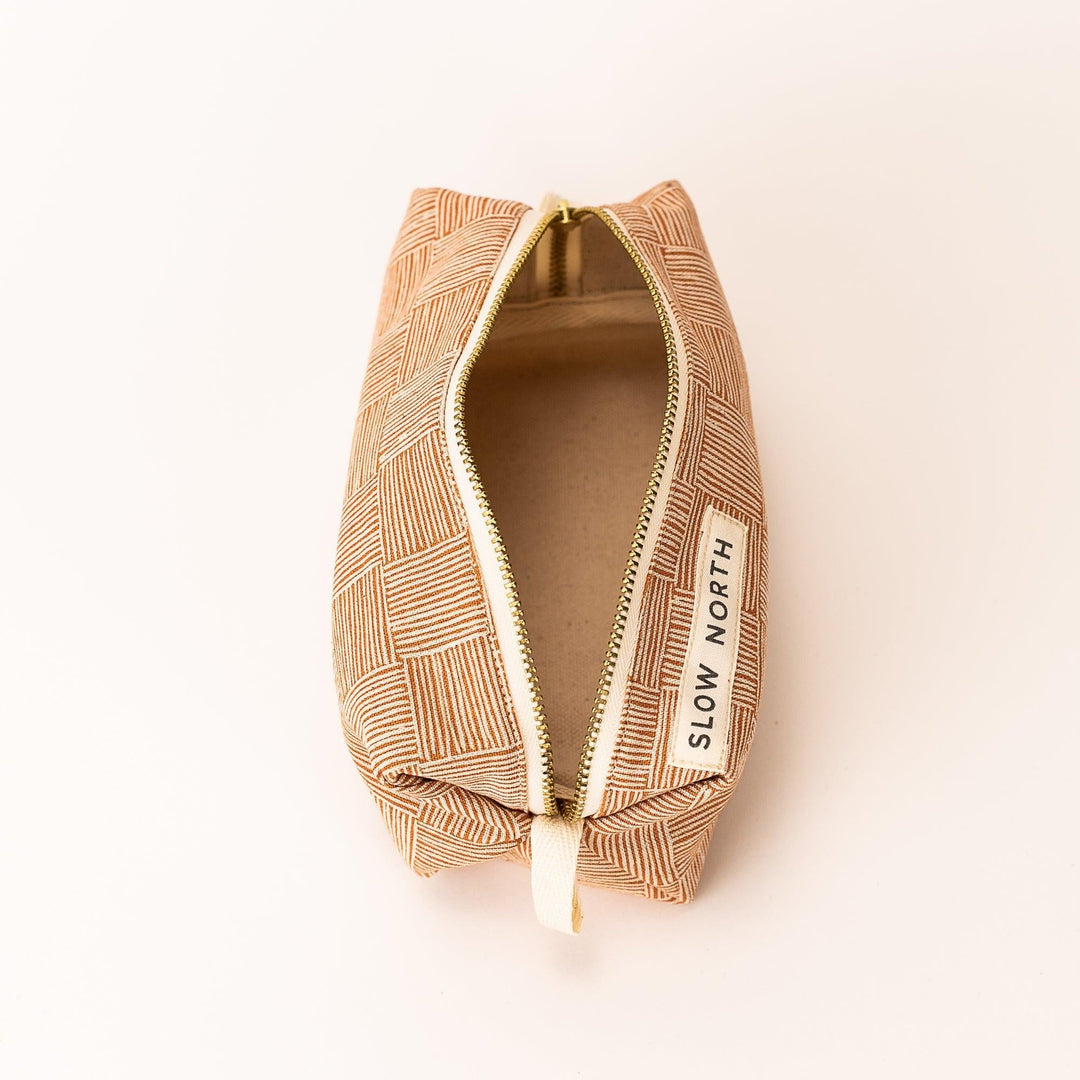 Compact travel pouch with soft cotton-linen exterior and zipper closure.