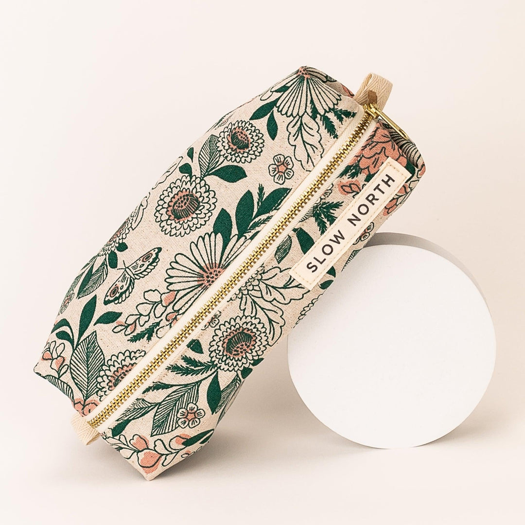 Compact travel pouch with nature-themed pattern and structured shape.