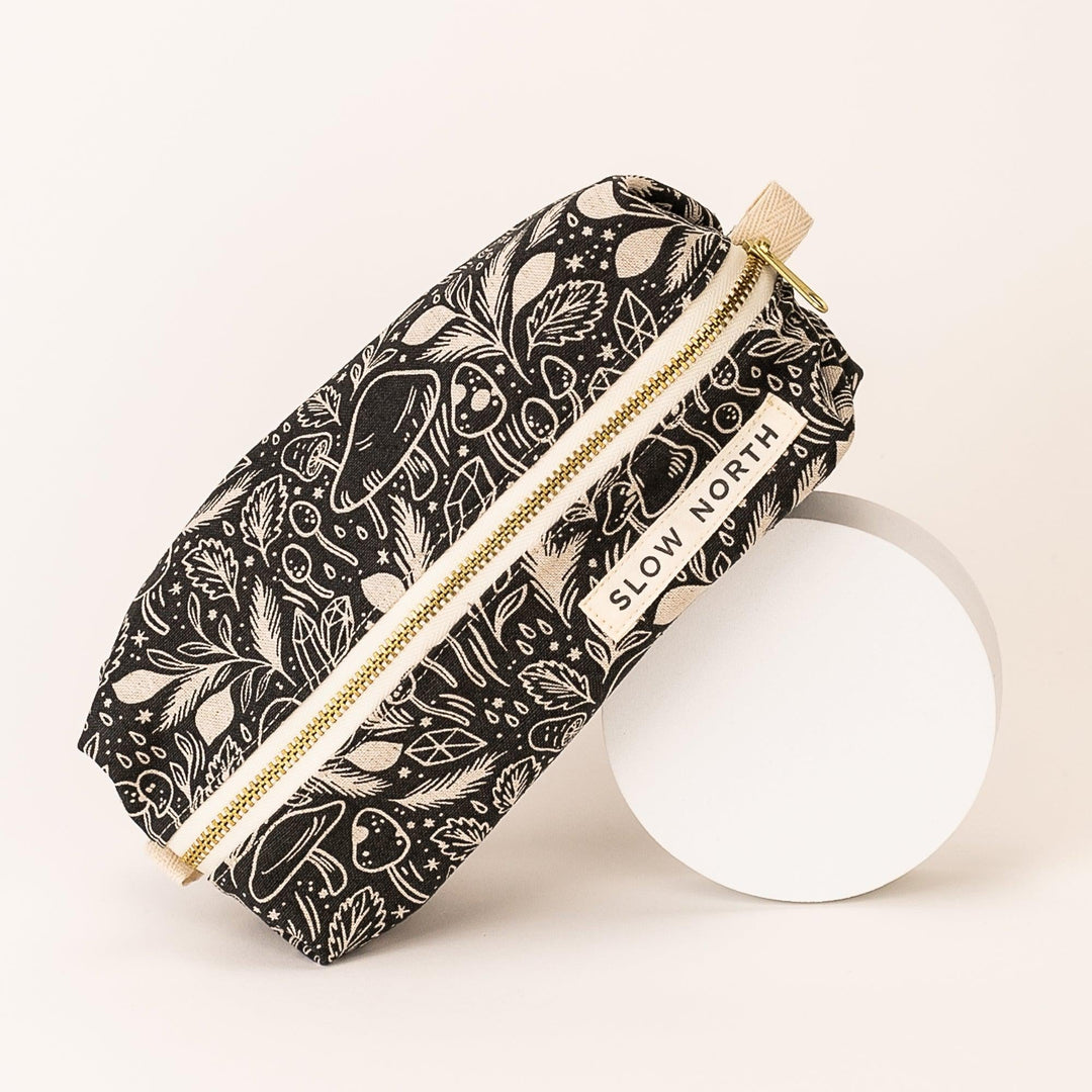 Cotton-linen pouch with mushroom artwork and brass zipper closure.