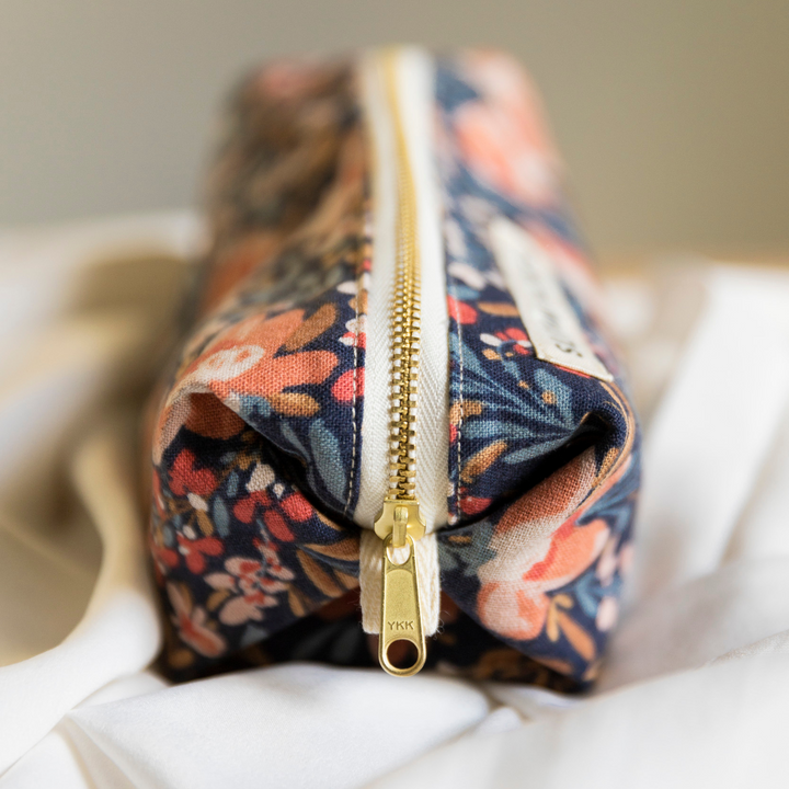 Pom Blossom pouch with vibrant floral pattern and self-standing form.