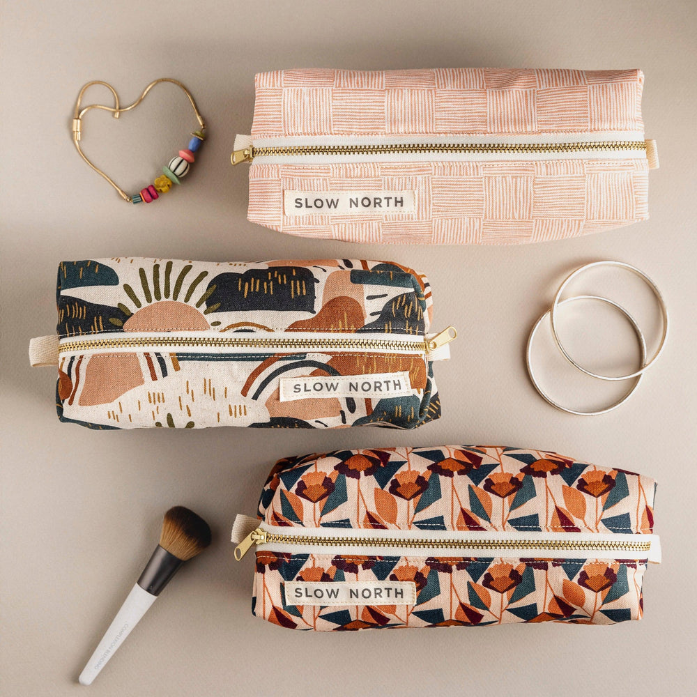 Cotton-linen travel pouch with vibrant rainbow design and zipper closure.