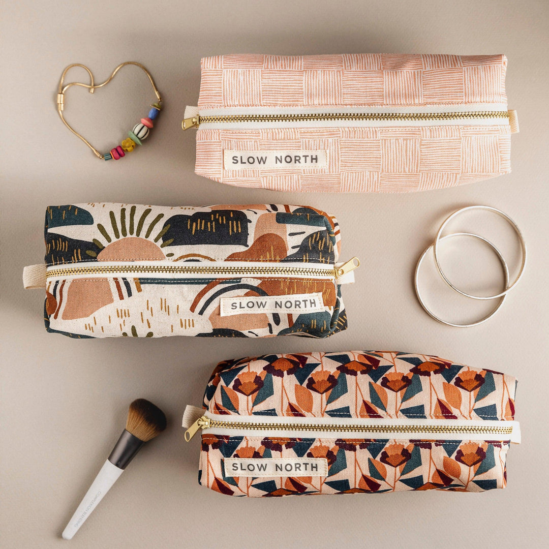 Cotton-linen travel pouch with vibrant rainbow design and zipper closure.