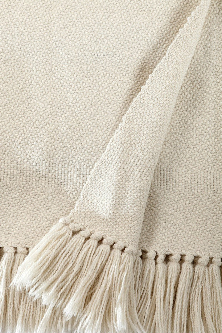 Close-up of the ivory twill weave and hand-tied fringe on a merino and llama wool throw.