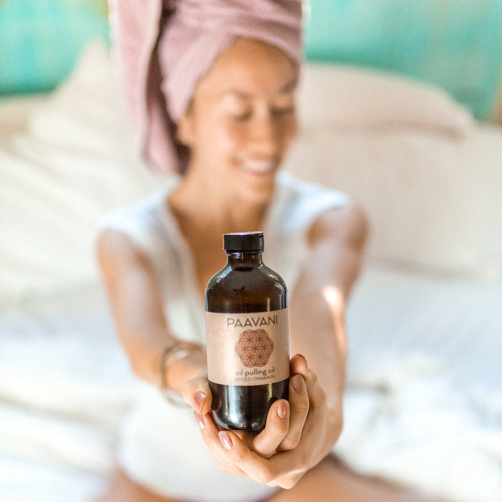 Bottle of cinnamon Ayurvedic oil-pulling blend with cinnamon and herbs.