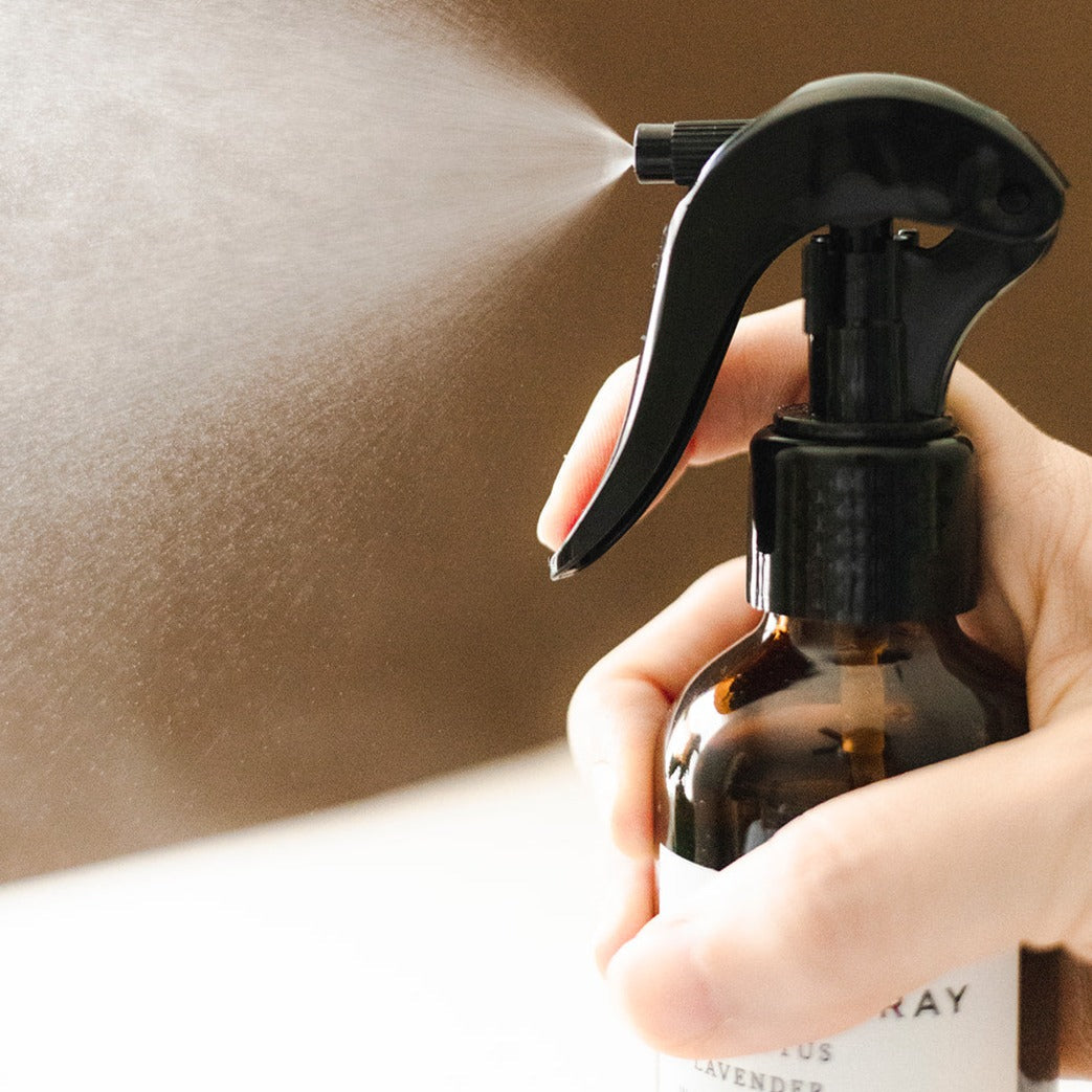 Shangri-La linen spray bottle with botanical accents.