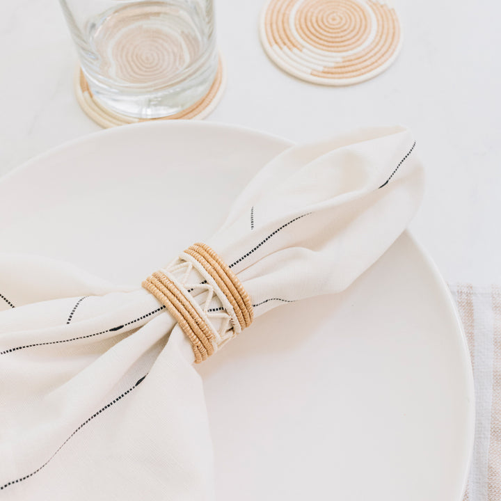 Handwoven white sisal napkin rings with a basket-weave pattern.