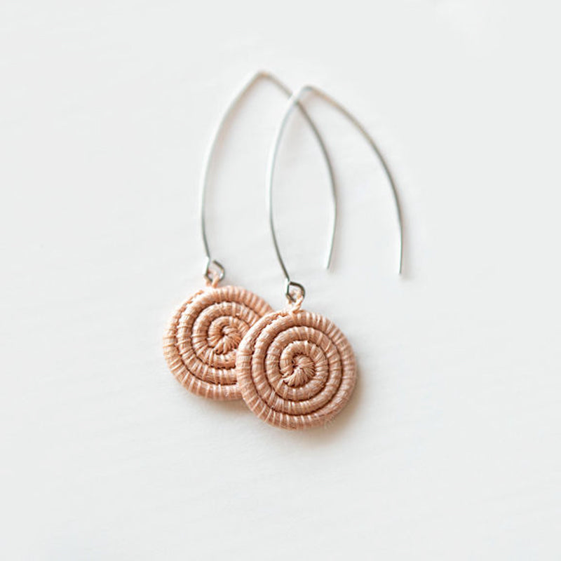 Blush hand-woven sisal earrings with an intricate woven design.