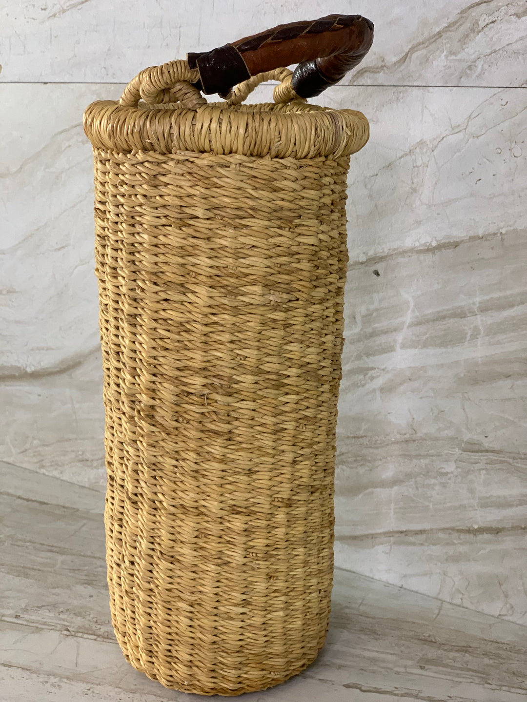 Handwoven straw Astoria vase and wine-bottle holder with a leather handle.