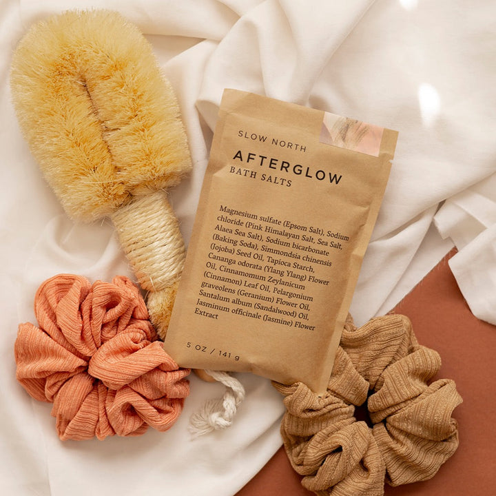 Afterglow bath salts shown in biodegradable kraft pouch packaging.