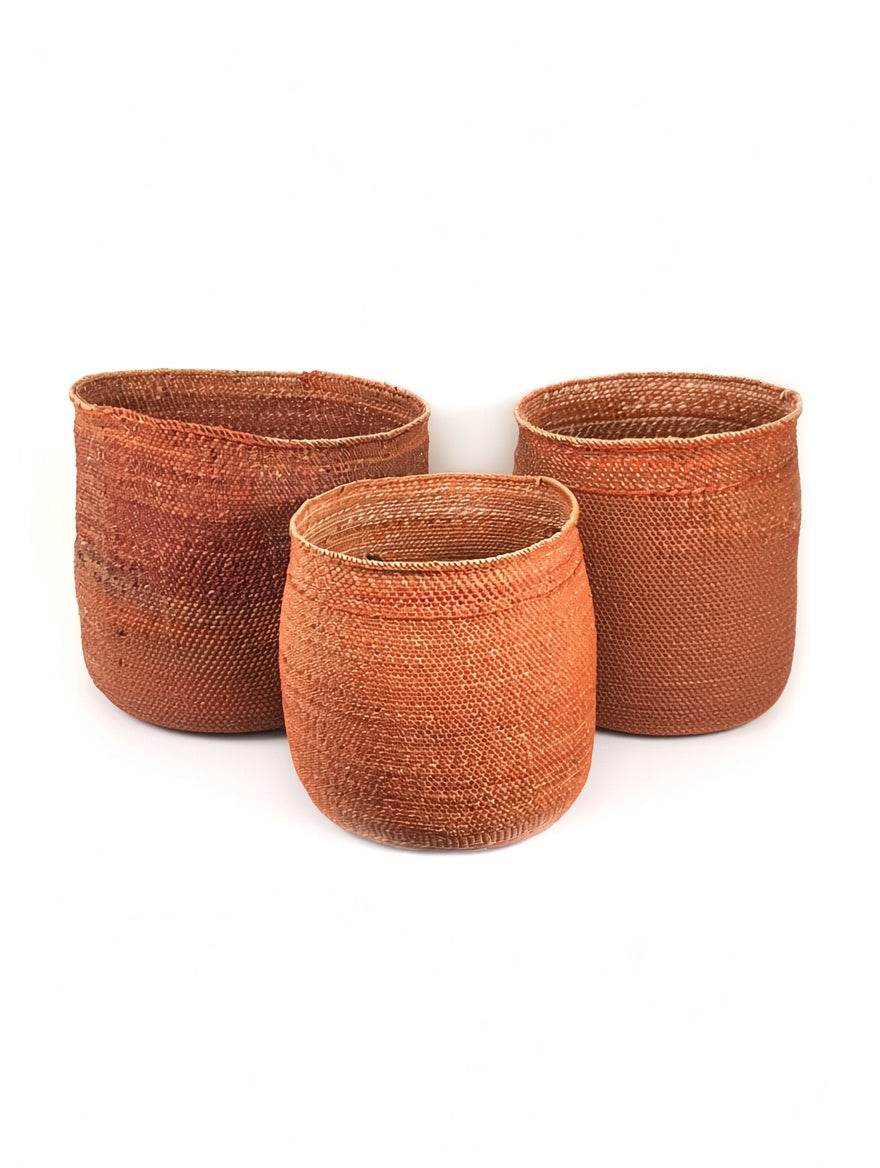 Three terracotta Auburn Iringa baskets in medium, large and extra large, handwoven in milulu grass