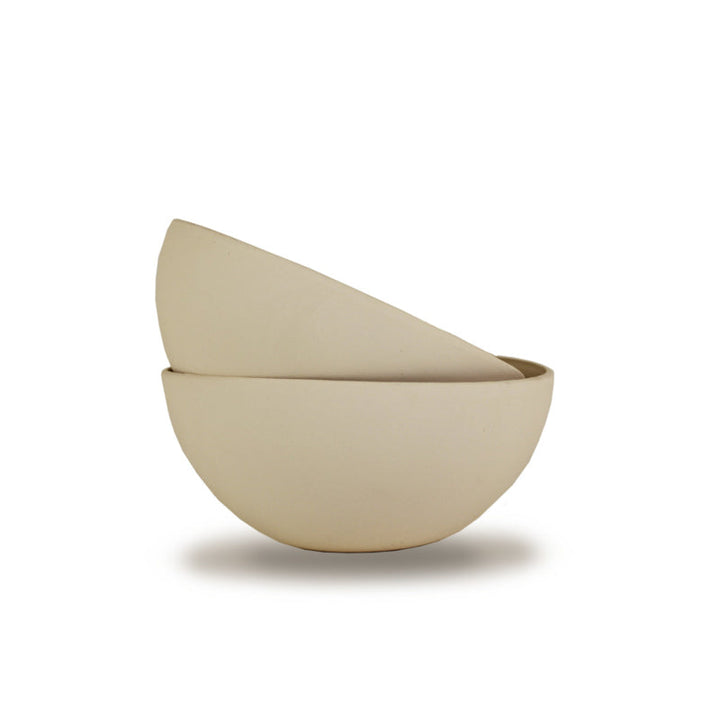Handmade porcelain bowl in cream with smooth, rounded edges.