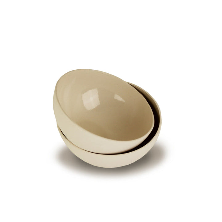 Handmade porcelain bowl in cream with a smooth, rounded shape.