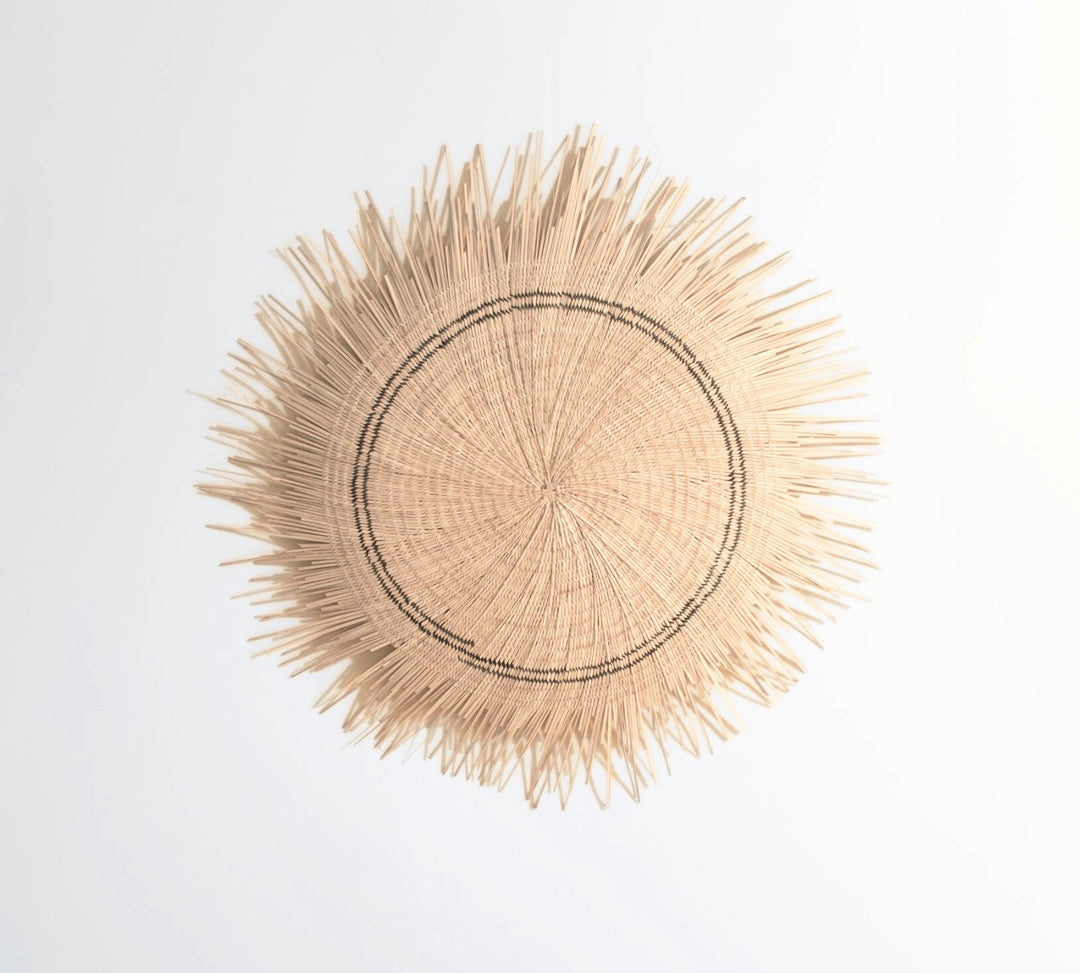 Natural woven sun circle wall art with a round, textured radiating design.