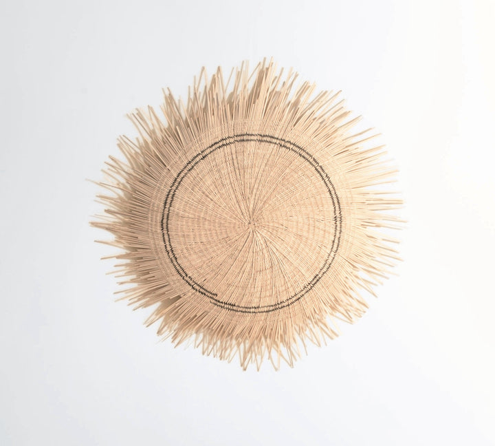 Natural woven sun circle wall art with a round, textured radiating design.