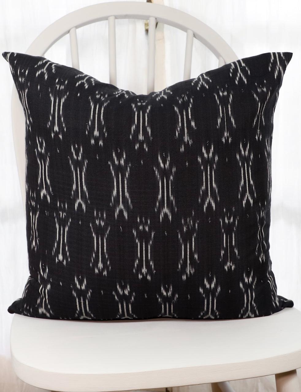 Handwoven black and white ikat cotton throw pillow cover, front view.