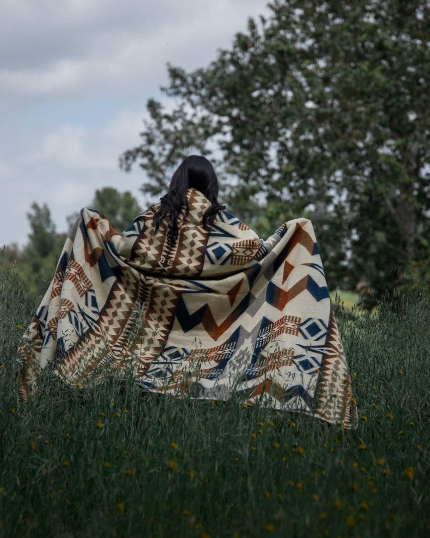 Navy and earth-tone Awa throw blanket in 100% recycled acrylic, 92 by 78 inches.