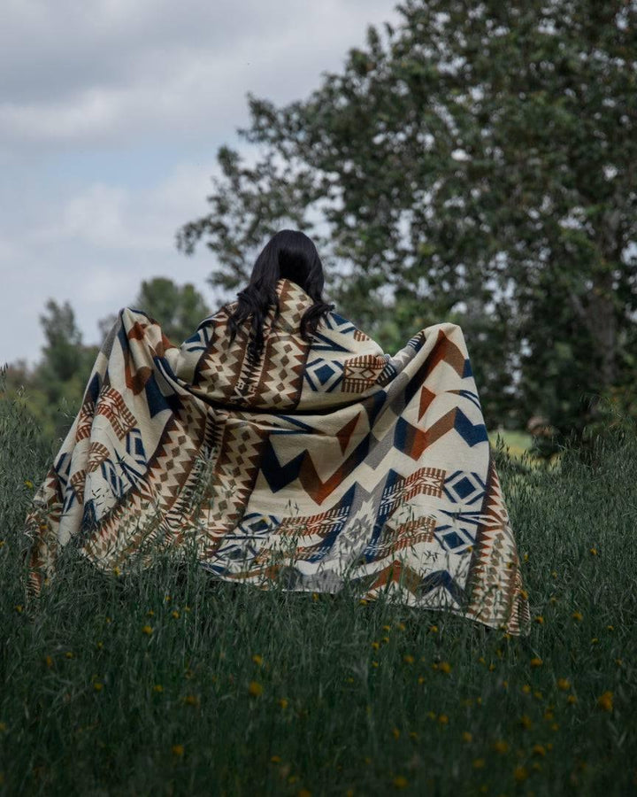 Navy and earth-tone Awa throw blanket in 100% recycled acrylic, 92 by 78 inches.