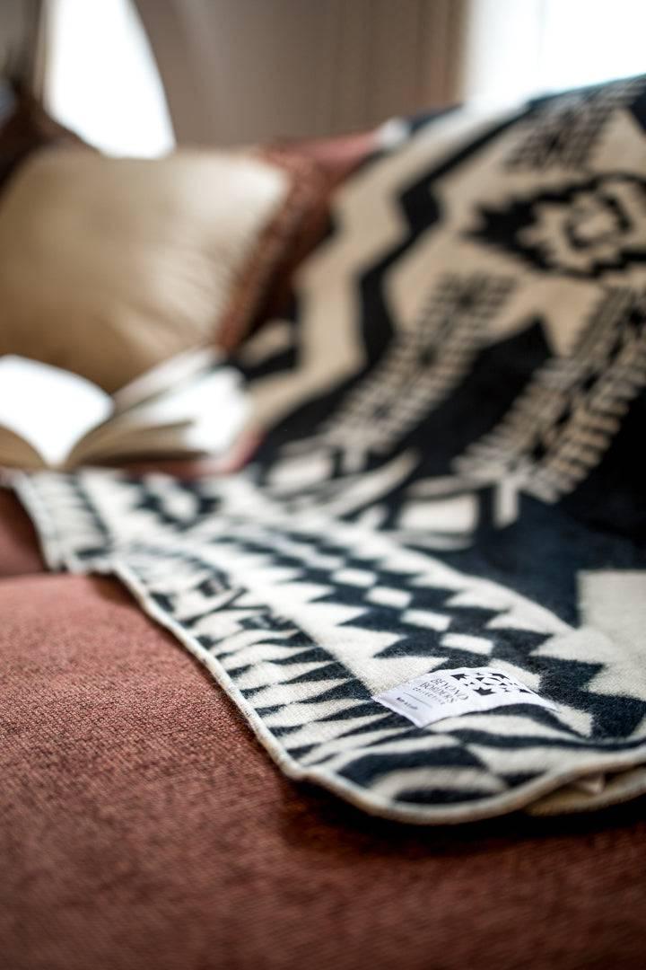 Natural black Awa throw blanket in 100% recycled acrylic, 92 by 78 inches.