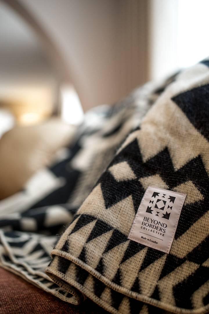 Black-and-cream Awa Andean blanket with zigzag and diamond banding.