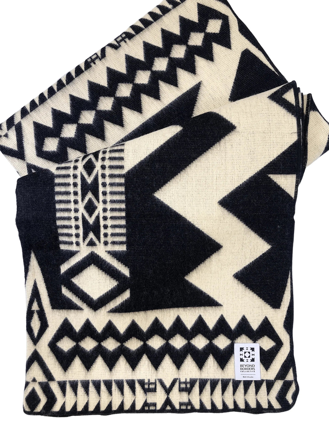 Awa Andean throw blanket in black and natural cream, woven with bold triangles and stepped diamonds.