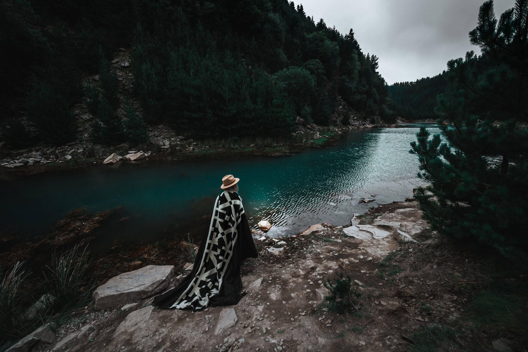 Minimalist Destino Andean blanket, deep black ground with a graphic cream band.