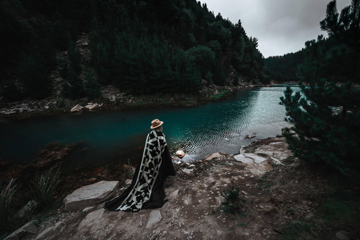 Minimalist Destino Andean blanket, deep black ground with a graphic cream band.