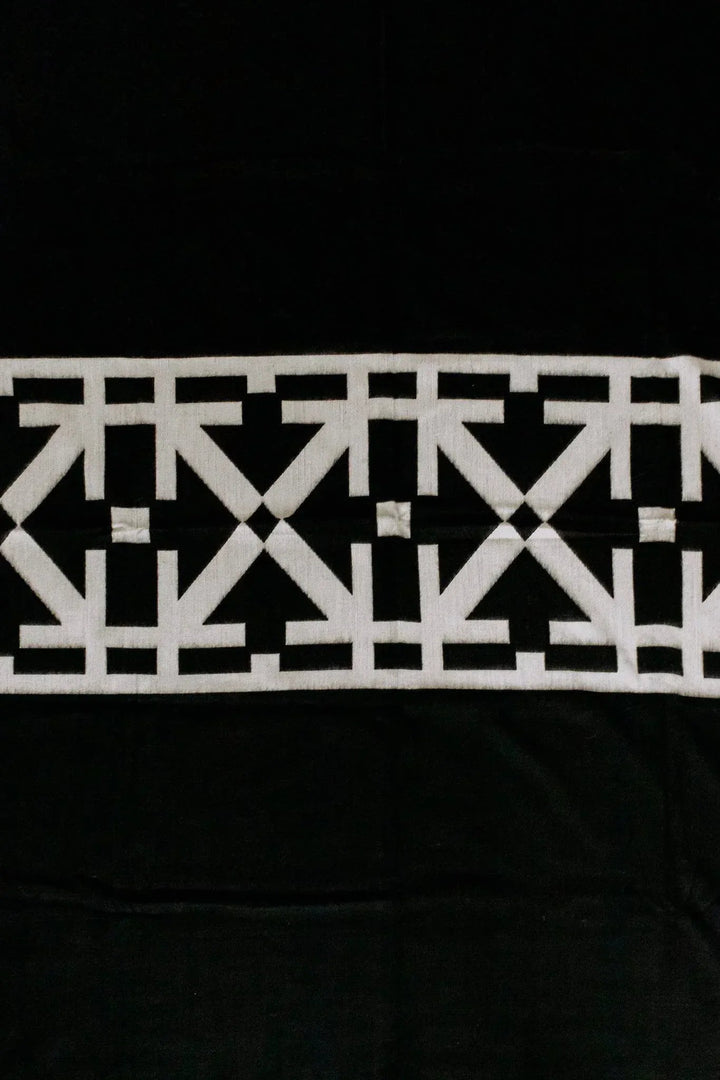 Destino minimalist Andean throw blanket in black with a bold abstract cream linework band.