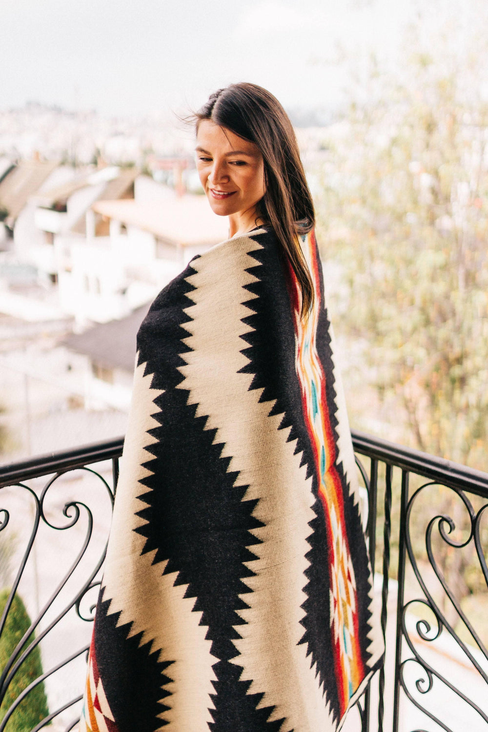 Cream and black Tsachila throw blanket with colorful Andean geometric pattern in turquoise, burgundy, mustard, and rust.