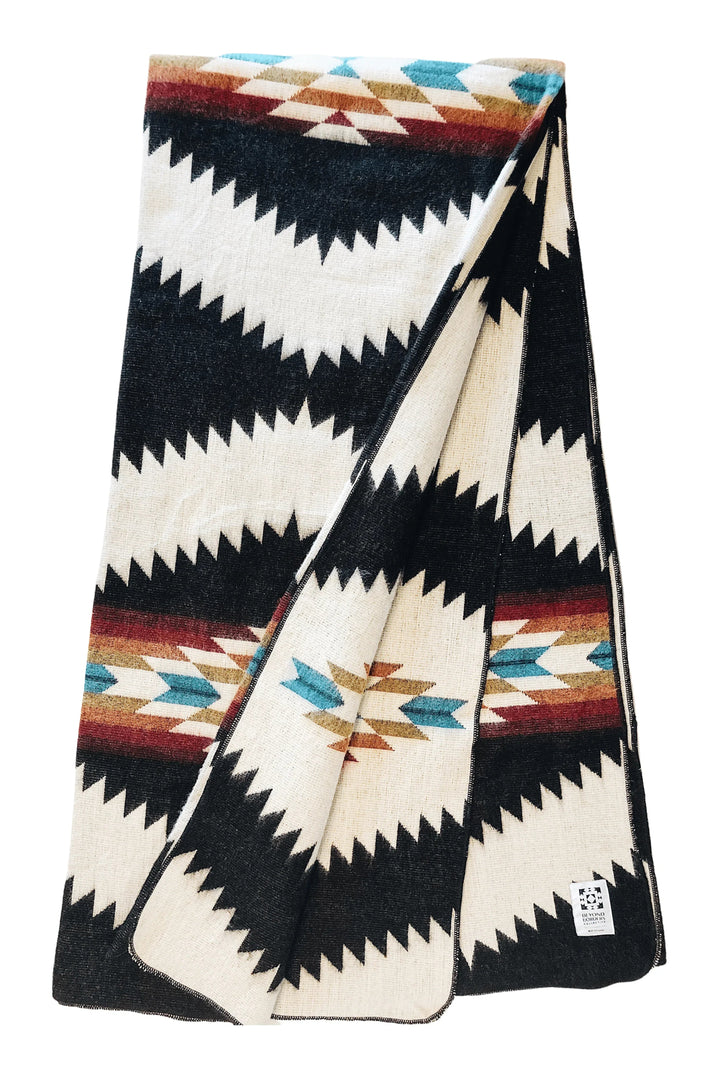 Tsachila Colorful Black Andean blanket in cream with bold black zigzag bands and turquoise, burgundy, and mustard diamond accents.