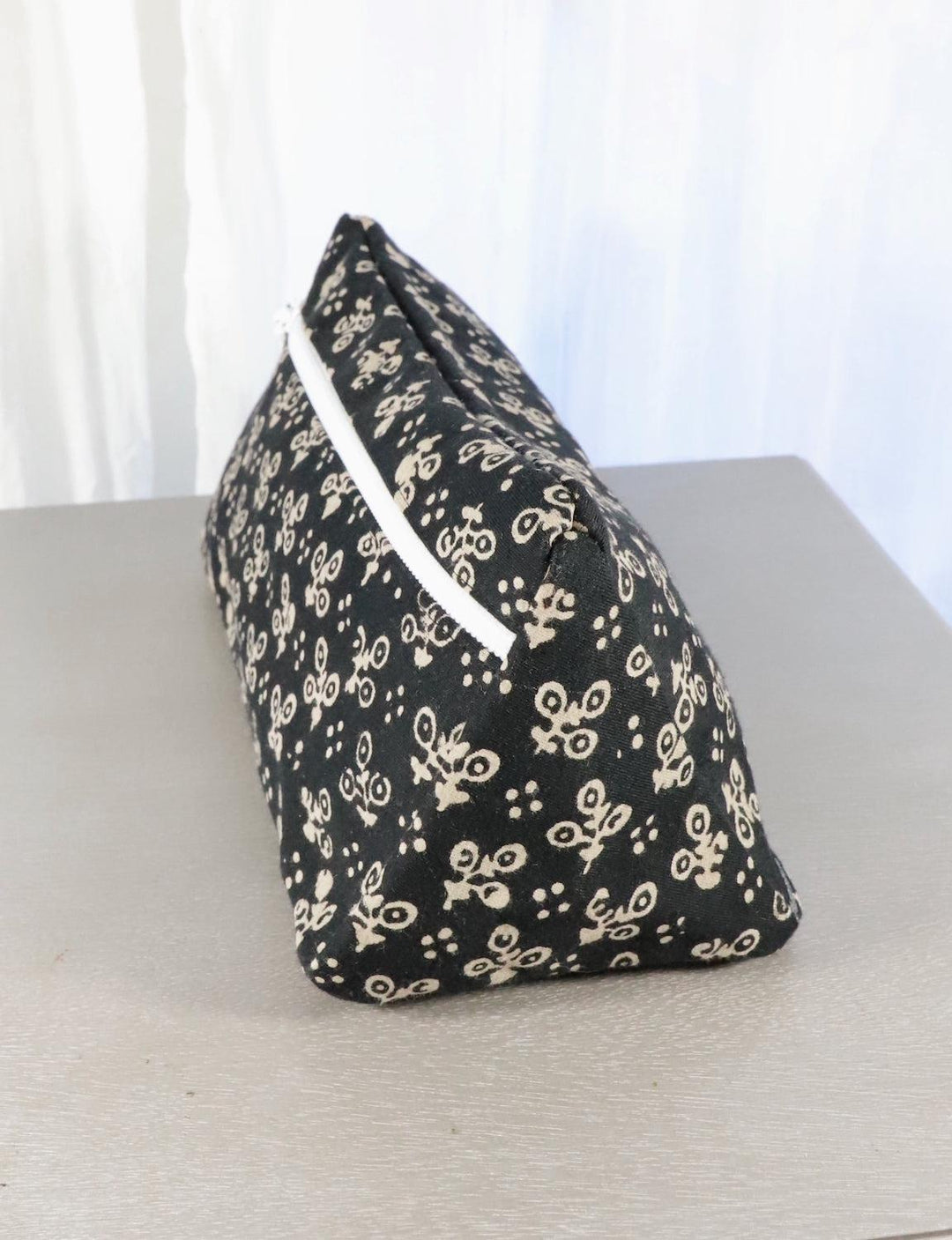 Black cotton toiletry bag with a dot or floral block print design.