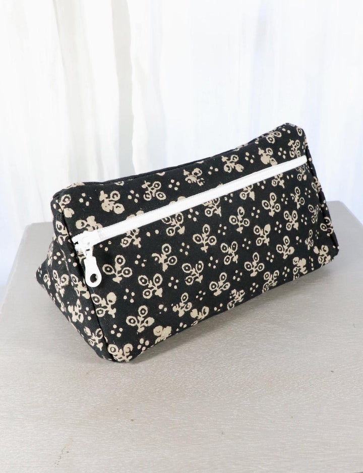 Black cotton block print toiletry bag with floral and dot patterns.