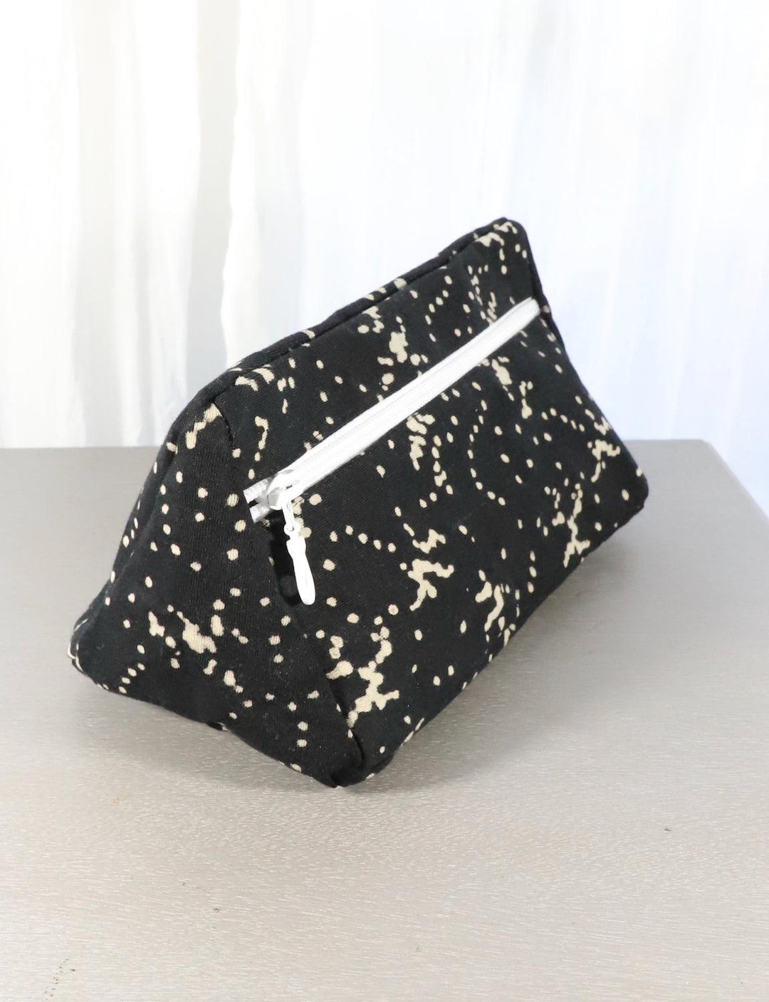 Black cotton toiletry bag with dotted and floral block print patterns.