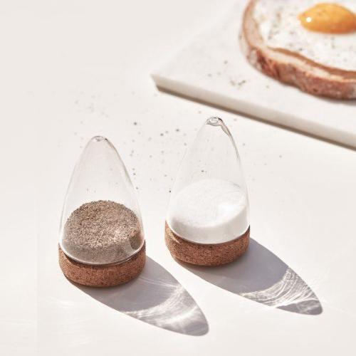 Glass salt and pepper shakers with cork stoppers, clear glass bottles.