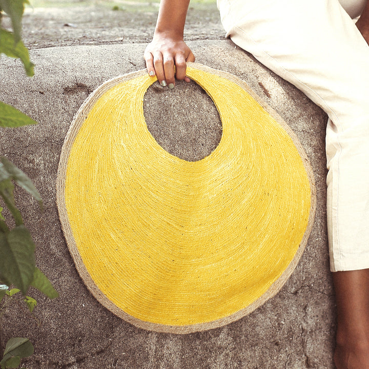 Round woven tote bag made of jute with a natural finish and a simple design.