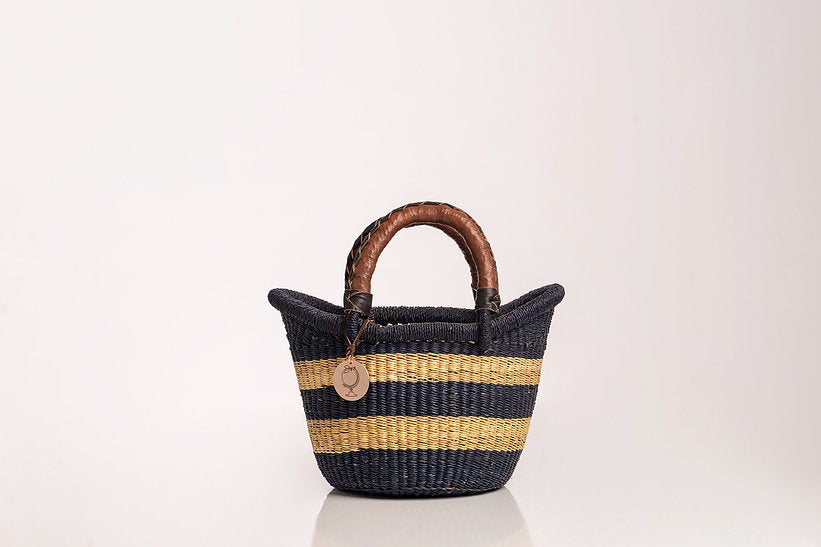 The Petite Victoria handwoven straw basket bag with a natural woven design.