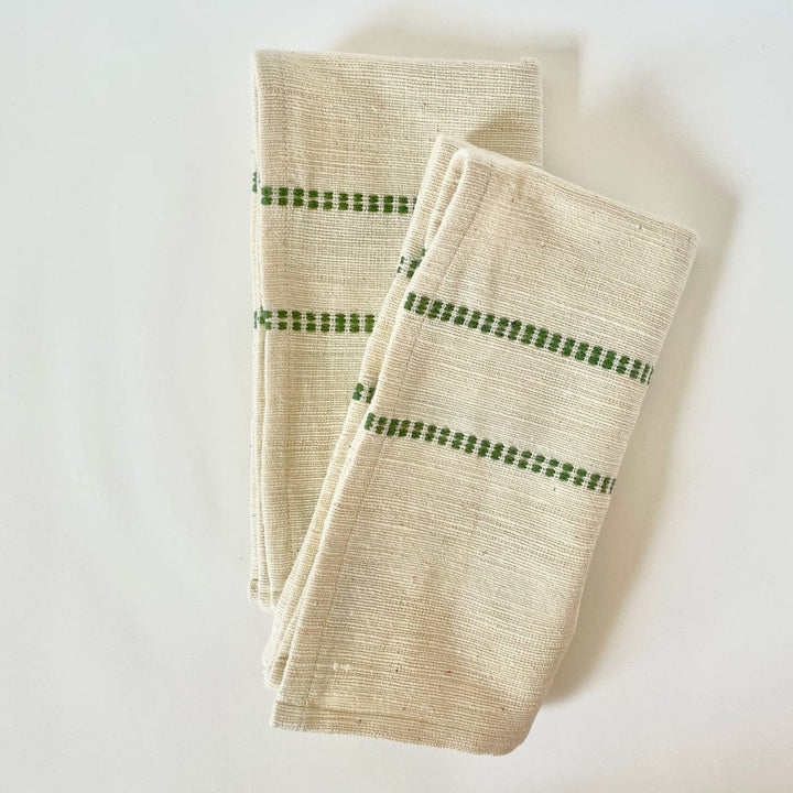 Pair of natural cotton dinner napkins with a cedar green check band, folded