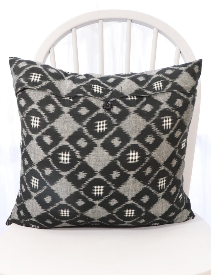 Handwoven black and grey ikat cotton throw pillow cover with a geometric pattern.