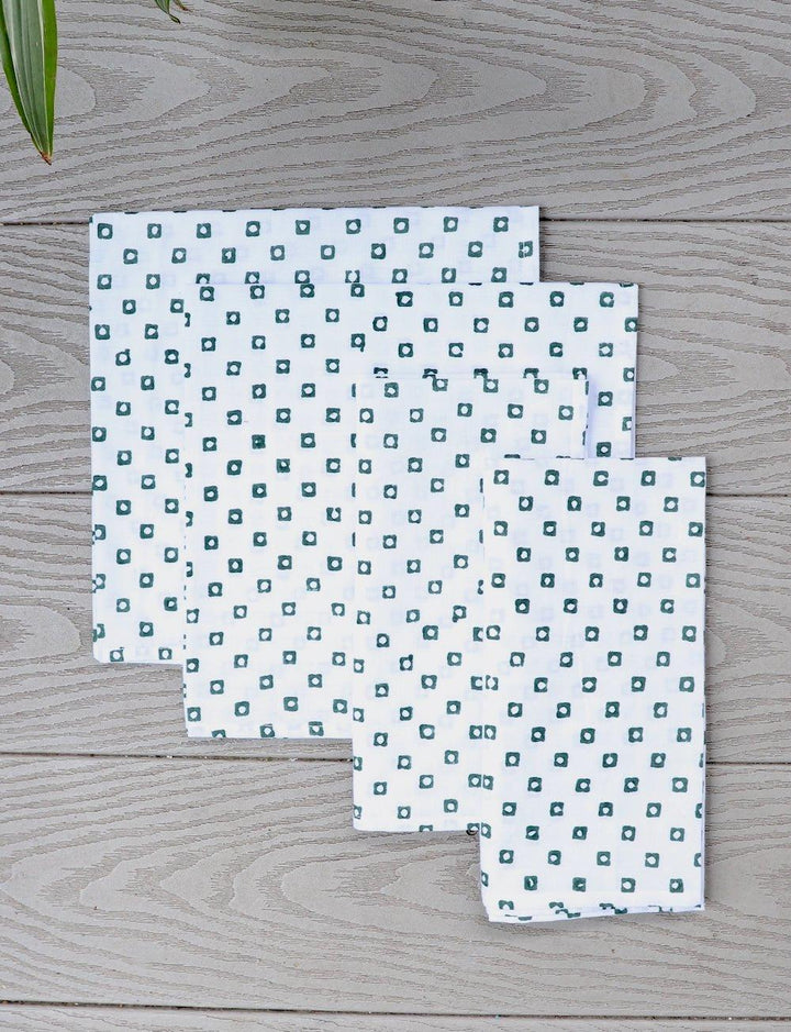Set of four cotton napkins with a green square block print.