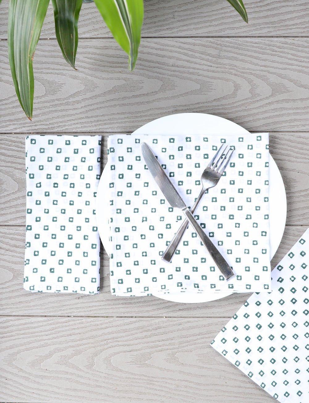 Set of four cotton napkins with a green square block print.