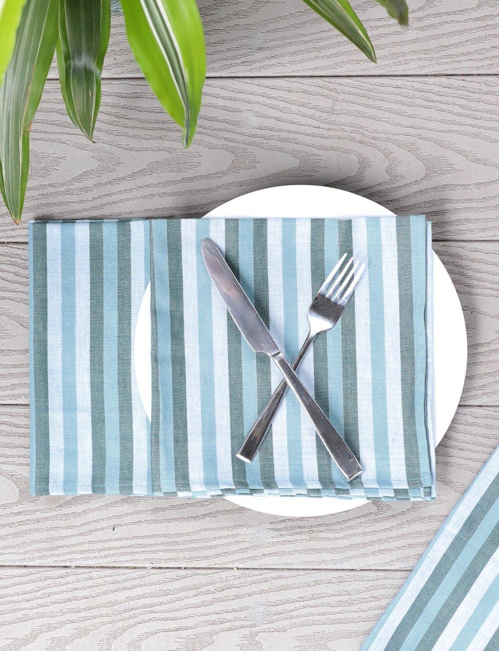 Set of four blue and white striped cotton napkins.