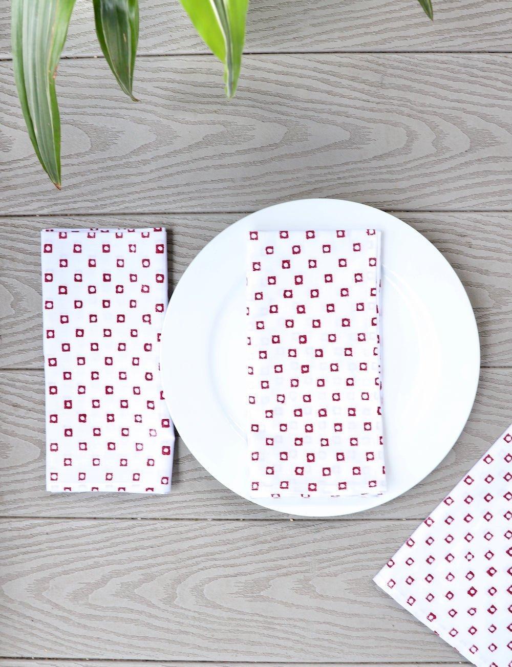 Set of four cotton napkins with a red square block print.