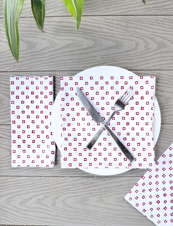 Set of four cotton napkins with a red square block print.