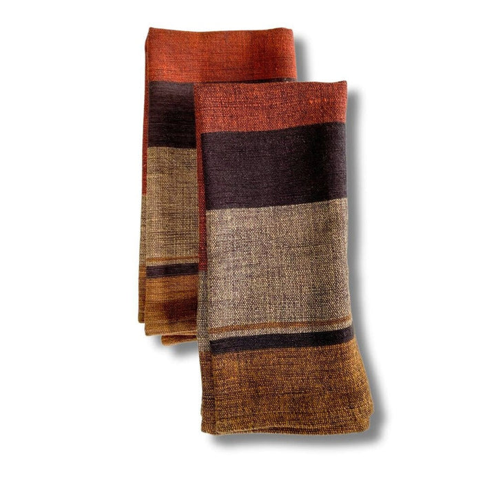 Pair of copper color block cotton dinner napkins, folded