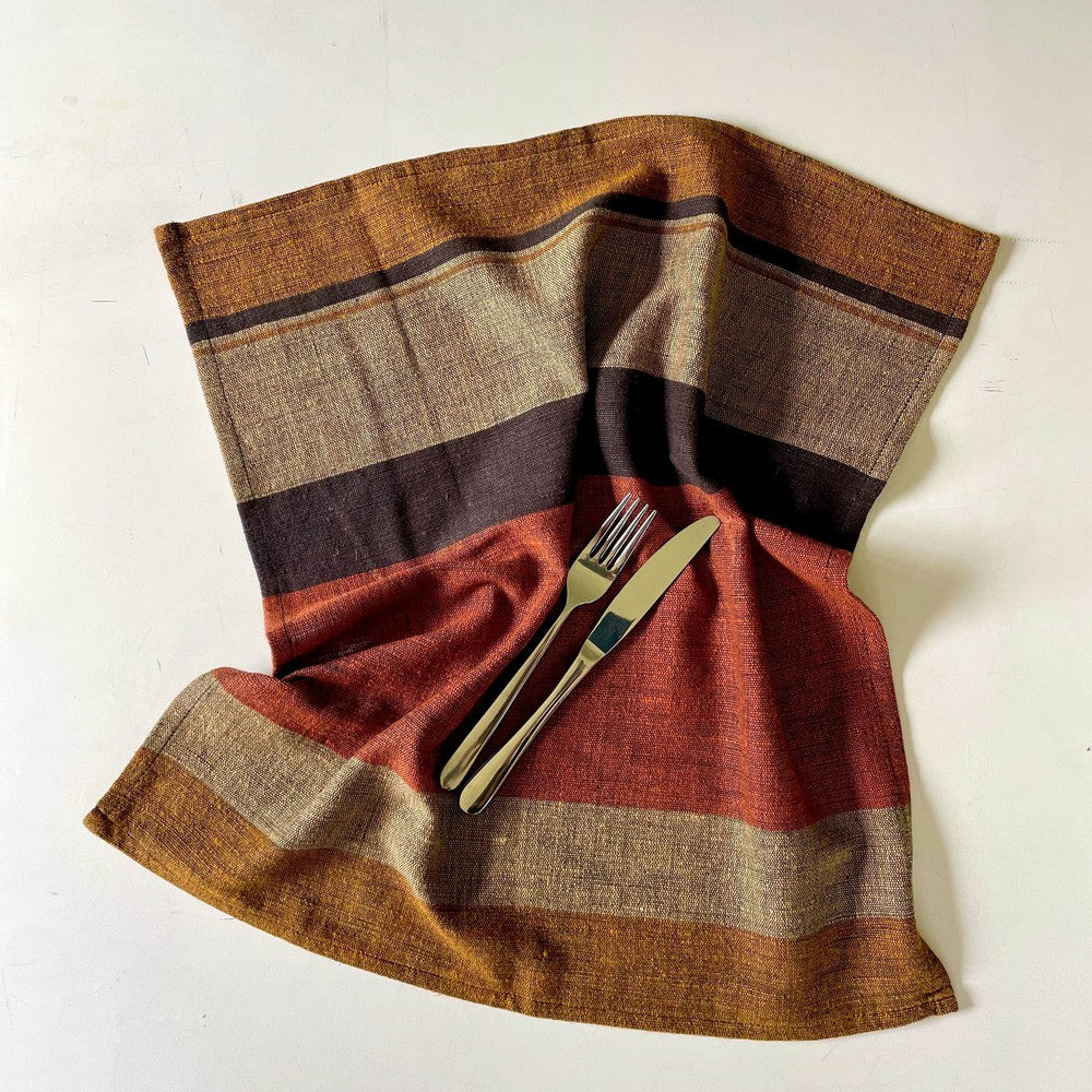 Copper color block napkin laid open with a knife and fork