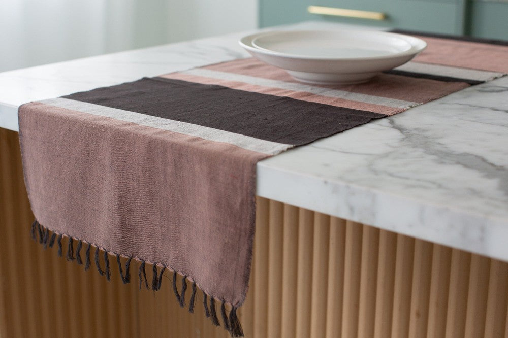 Blush color block table runner hanging off the end of a kitchen island
