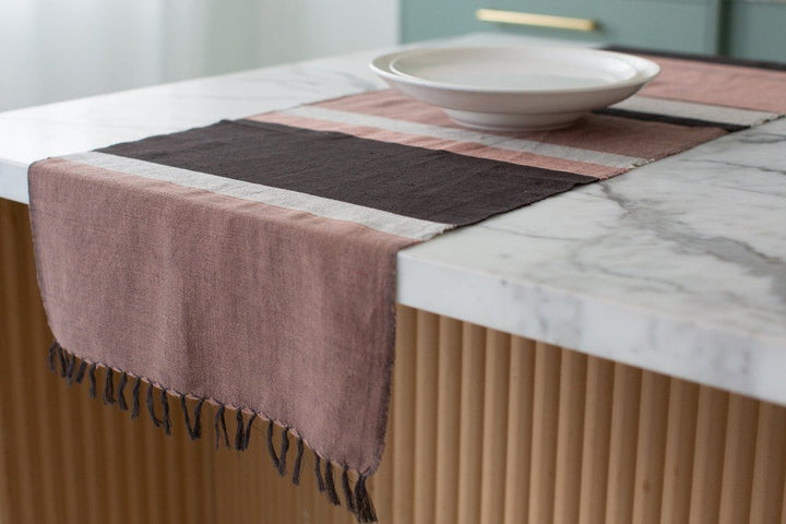 Blush color block table runner hanging off the end of a kitchen island